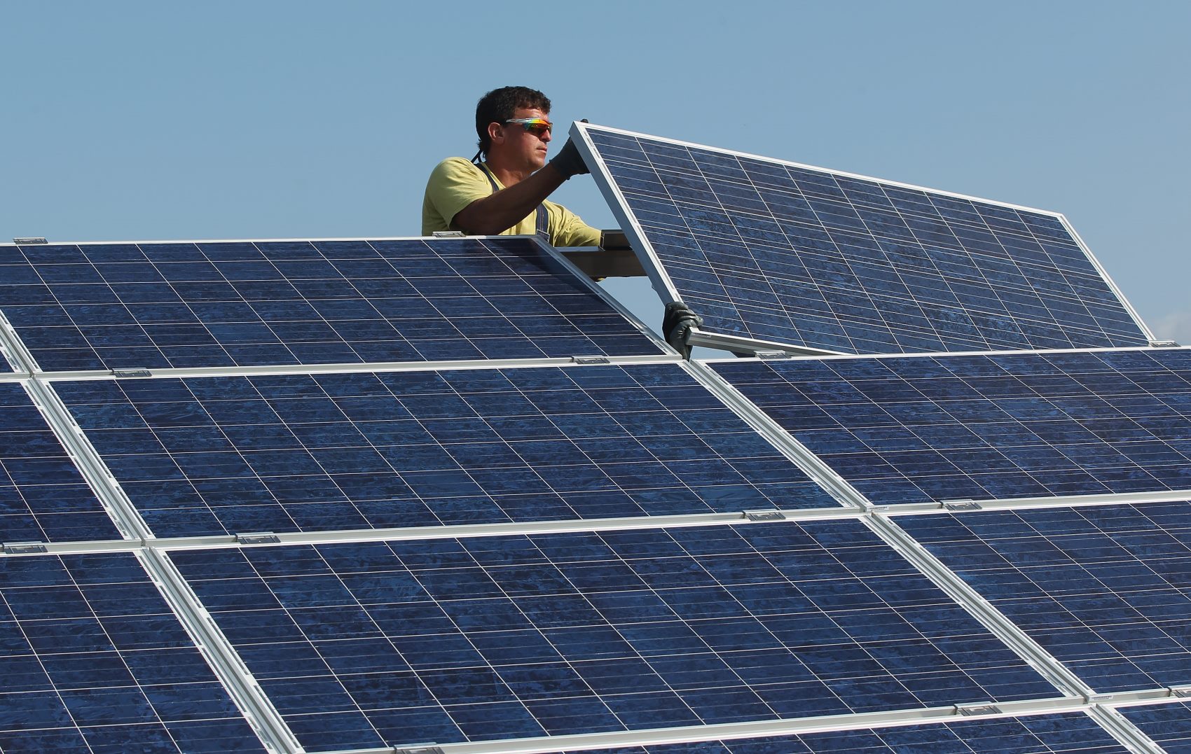 Un trabajador coloca un panel solar en una instalación. 