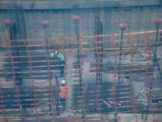 Vista de dos obreros, trabajando en el forjado de una obra, a través de una red de seguridad, en unos edificios en construcción, en Vallecas. FOTO: Carlos Luján - Europa Press