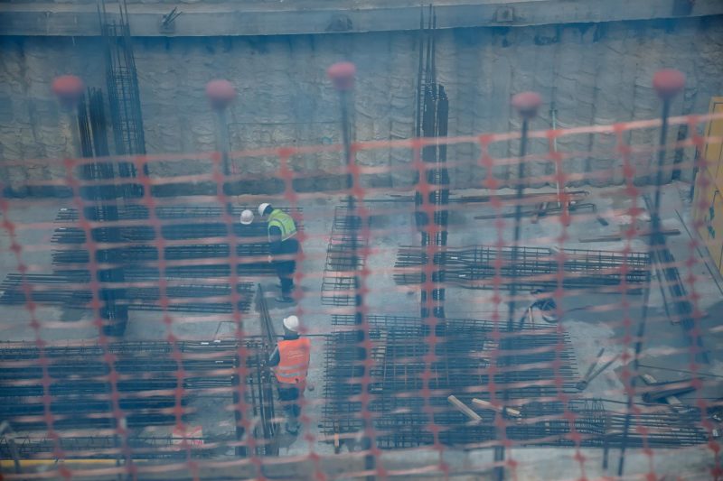 Vista de dos obreros, trabajando en el forjado de una obra, a través de una red de seguridad, en unos edificios en construcción, en Vallecas. FOTO: Carlos Luján - Europa Press