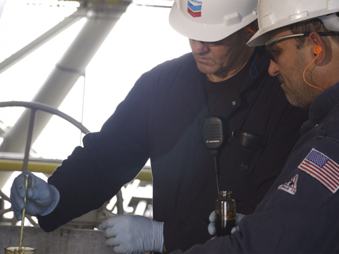 Dos operarios de Chevron valoran la calidad del petróleo. FOTO: Chevron