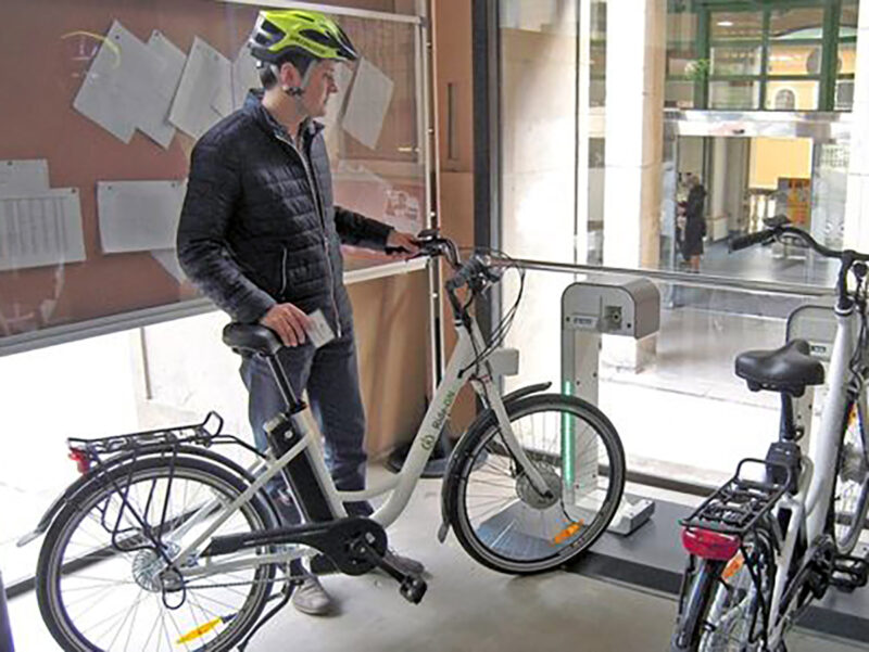 Un usuario cogiendo una de las bicicletas eléctricas. FOTO: Ayuntamiento de Pamplona